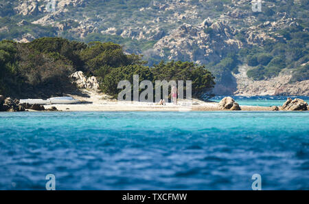 Ein nicht identifiziertes Paar sonnen sich auf der schönen Cavalieri Strand (Spiaggia di Cavalieri) vom türkisfarbenen Meer gebadet. Maddalena Archipel Stockfoto