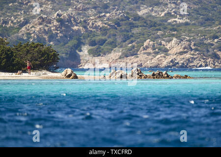 Ein nicht identifiziertes Paar sonnen sich auf der schönen Cavalieri Strand (Spiaggia di Cavalieri) vom türkisfarbenen Meer gebadet. Maddalena Archipel Stockfoto