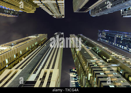 (Andere Perspektive) atemberaubenden Blick von unten nach oben über einige hohe Hochhäuser und Türme beleuchtet in der Nacht in Dubai Marina. Stockfoto