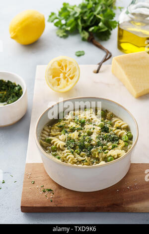 Minestrone, Italienische Gemüsesuppe mit Nudeln und Wirsing. Mit Koriander Pesto und Parmesan serviert. Gesunde vegetarische Nahrung. Stockfoto