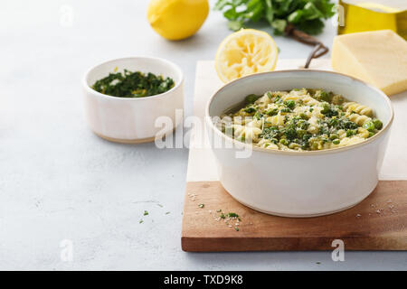 Minestrone, Italienische Gemüsesuppe mit Nudeln und Wirsing. Mit Koriander Pesto und Parmesan serviert. Gesunde vegetarische Nahrung. Stockfoto