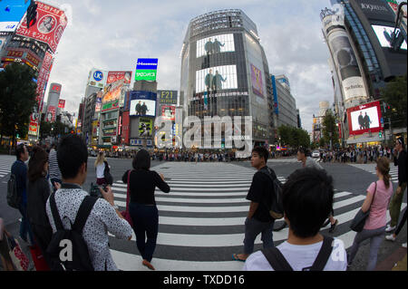 Shibuya Crossing in Tokio, Japan, ist bekannt für seine extrem beschäftigt Jagt, mit zebrastreifen Fußgänger in alle Richtungen gleichzeitig. Stockfoto