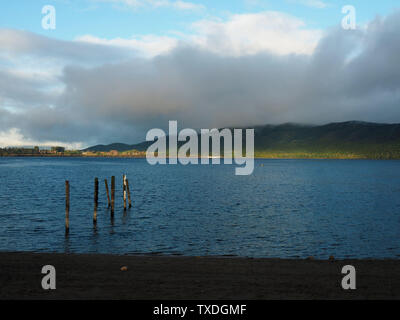 Die Sonne scheint auf die Azure Lake Te Anau an einem bewölkten Morgen Stockfoto