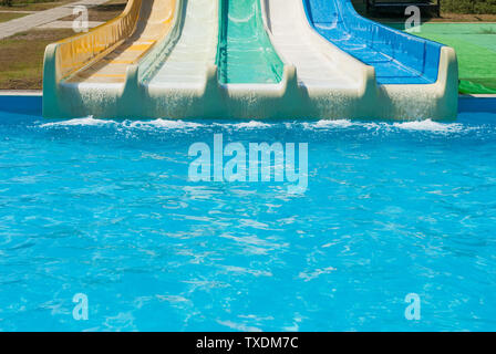 Bunte Wasserrutschen mit türkisfarbenen Pool im Vergnügungspark Aqua Park im Freien sonnigen Sommer Urlaub Tag Stockfoto