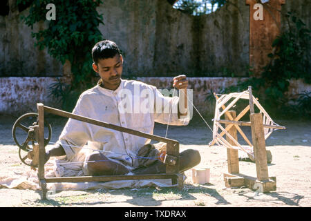 Junge Spinnen Garne aus Baumwolle auf charkha, Gujarat, Indien, Asien Stockfoto