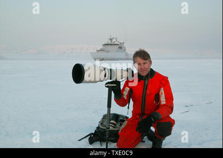 Outdoor Fotograf Øyvind Martinsen an Billefjorden, Spitzbergen, Svalbard, Norwegen. Im Hintergrund ist das Schiff KV Svalbard von der norwegischen Küstenwache. Mai, 2006. Stockfoto