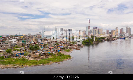 Die Slums der armen Menschen auf dem Hintergrund einer großen Stadt. Die Stadt Manila, armen und reichen Regionen. Kontrast sozialen Schichten. Stockfoto