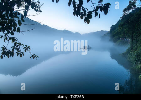 Nebel füllt Xiao Dongjiang 5 (Am frühen Morgen des Sommers, dicker Nebel durchdringt Xiao Dongjiang und in der Licht und Schatten auf den Sonnenaufgang, Fischer bereiten Sie Fisch.) Stockfoto