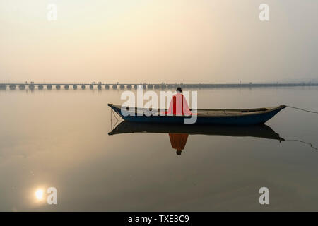 Sadhu mit rotem Schal auf einer Bootsfahrt auf dem Ganges bei Sonnenaufgang, Allahabad Kumbh Mela, der weltweit größte religiöse Versammlung, Uttar Pradesh, Indien Stockfoto