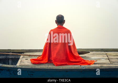 Sadhu mit rotem Schal auf einer Bootsfahrt auf dem Ganges bei Sonnenaufgang, Allahabad Kumbh Mela, der weltweit größte religiöse Versammlung, Uttar Pradesh, Indien Stockfoto