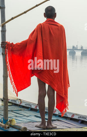 Sadhu mit rotem Schal auf einer Bootsfahrt auf dem Ganges bei Sonnenaufgang, Allahabad Kumbh Mela, der weltweit größte religiöse Versammlung, Uttar Pradesh, Indien Stockfoto