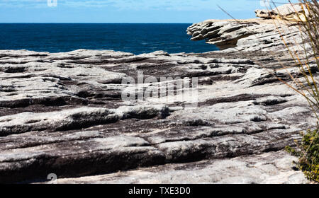 Oceanside felsigen Klippe Sandstein wave Bergrücken mit blauen Küste Meer und Himmel im Hintergrund Stockfoto