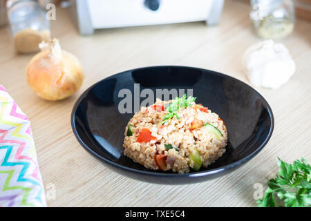 Bulgur Salat mit Gemüse auf dem Küchentisch mit Zutaten. Arabisch couscous Salat. Stockfoto