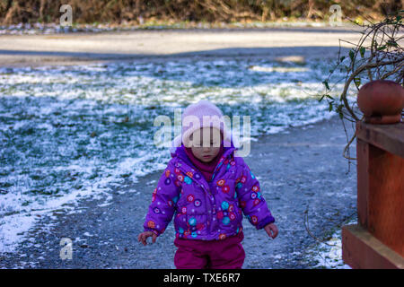 20 Monate altes Baby genießt das schöne Wetter draußen. Kleinkind Mädchen Porträts in natürlichem Licht. Kleines Mädchen Nahaufnahme Bild in der Natur, im Winter Stockfoto