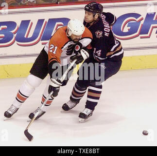 PHI 20000021005 - 10. FEBRUAR 2000 - Philadelphia, Pennsylvania, USA: Edmonton von Bert Robertsson (14) packt Flyer "Sandy McCarthy's Stick ihn weg von den Puck während einer Mitte zu halten - Eis Kampf während der ersten Periode Philadelphia Flyers-Edmonton Oilers NHL Hockey Aktion an der First Union Center in Philadelphia, 10. Februar 2000. Edmonton besiegt Philadelphia 3-2. rg/jca/John C. Anderson UPI Stockfoto
