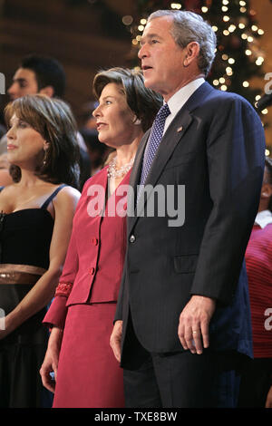 First Lady Laura Bush (L) und Präsident George W. Bush singen "Hark The Herald Angels Sing" beim Finale der 24. jährlichen "Weihnachten in Washington "Pageant 11. Dezember 2005 im National Building Museum, Washington, DC. Der Jahresurlaub musikalische Feier zugunsten der Kinder National Medical Center wird auf TNT 14. Dezember 2005 ausgestrahlt. (UPI Foto/Chip Somodevilla/Pool) Stockfoto