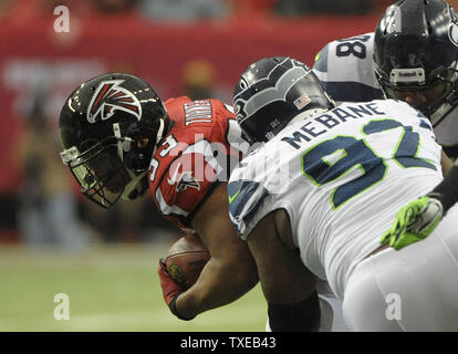 Atlanta Falcons zurück laufen Michael Turner (33) wird von Seattle Seahawks defensive gestoppt Angriff Brandon Mebane (92) während der ersten Hälfte des NFL divisional Spiel im Georgia Dome in Atlanta am 13. Januar 2013. UPI/David Tulis Stockfoto