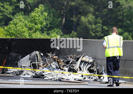 Beamte einer tödlichen Flugzeugabsturz untersuchen Nach dem einmotorigen Flugzeugen in einem mittleren Wand auf der stark befahrenen I-285 Interstate Highway zugeschlagen, nachdem das Handwerk in der Nähe De Kalb-Peachtree Flughafen zog nördlich von Atlanta, in Atlanta, Georgia, 8. Mai 2015. Nach Angaben der Behoerden, vier Personen an Bord der Piper PA-32 Flugzeuge starb bei einem Brand, der Verkehr angehalten in alle Richtungen aber Passanten Verletzungen entgangen. Foto von David Tulis/UPI Stockfoto