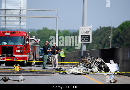 Beamte einer tödlichen Flugzeugabsturz nach einem einmotorigen Luftfahrzeug in einem zwischenstaatlichen median Wand auf der stark befahrenen I-285 Interstate Highway zugeschlagen wird, stoppen Verkehr in allen Richtungen, in Atlanta, Georgia, nördlich von Atlanta, 8. Mai 2015. Nach Angaben der Behoerden, vier Personen an Bord der Piper PA-32 Flugzeuge starb bei einem Brand aber Passanten entging Verletzung. Foto von David Tulis/UPI Stockfoto