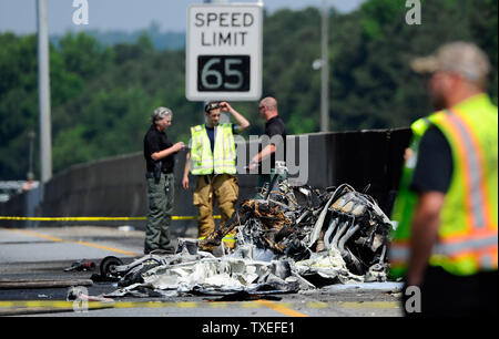 Beamte einer tödlichen Flugzeugabsturz nach einem einmotorigen Luftfahrzeug in einem zwischenstaatlichen median Wand auf der stark befahrenen I-285 Interstate Highway zugeschlagen wird, stoppen Verkehr in allen Richtungen, in Atlanta, Georgia, nördlich von Atlanta, 8. Mai 2015. Nach Angaben der Behoerden, vier Personen an Bord der Piper PA-32 Flugzeuge starb bei einem Brand aber Passanten entging Verletzung. Foto von David Tulis/UPI Stockfoto