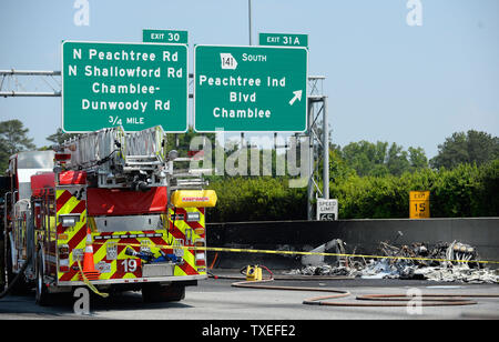 Beamte einer tödlichen Flugzeugabsturz nach einem einmotorigen Luftfahrzeug in einem zwischenstaatlichen median Wand auf der stark befahrenen I-285 Interstate Highway zugeschlagen wird, stoppen Verkehr in allen Richtungen, in Atlanta, Georgia, nördlich von Atlanta, 8. Mai 2015. Nach Angaben der Behoerden, vier Personen an Bord der Piper PA-32 Flugzeuge starb bei einem Brand aber Passanten entging Verletzung. Foto von David Tulis/UPI Stockfoto