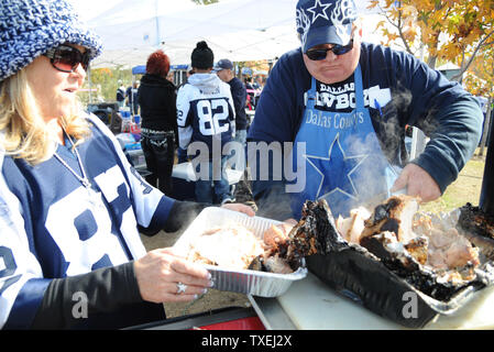 Steve Naylor, rechts, und seine Frau Janie, schnitzen ein Thanksgiving Truthahn während tailgating vor der Dallas Cowboys, Oakland Raiders Spiel bei AT&T Stadium in Arlington, Texas, am 28. November 2013. Naylor hat jeden Cowboy Thanksgiving Tag Spiel seit 1966 besucht. UPI/Ian Halperin Stockfoto