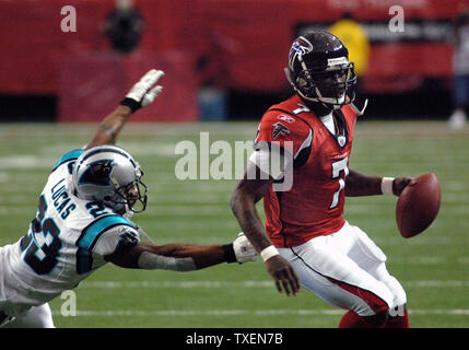 Atlanta Falcons Quarterback Michael Vick (7) Rum zum Nebenerwerb, die versuchen, an das Ladegerät von Carolina Panthers Cornerback Ken Lucas (23) im ersten Quartal Januar 1, 2006 entkommen, in Atlanta Georgia Dome. Die Leoparden besiegten die Falken, 44-11. (UPI Foto/Peter Stöger) Stockfoto