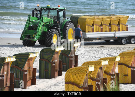 25. Juni 2019, Mecklenburg-Vorpommern, Binz: Ein Mitarbeiter eines Strandkorbverleih Firma transportiert Liegen für die Saison zum Strand des Ostseebades. Superwetter zieht Touristen an den Strand der Ostsee. Foto: Stefan Sauer/dpa-Zentralbild/ZB Stockfoto