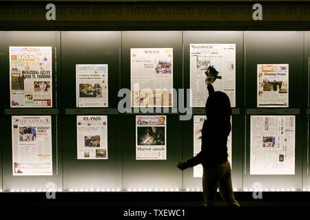 Dora Romero, 31, von Washington, DC, reinigt das Anzeigefenster an das Newseum in Washington am 20. Januar 2009, wo die vorderen Seiten aus die Gestrige Zeitung angezeigt werden. Barack Obama als 44. Präsident der Vereinigten Staaten vereidigt. (UPI Foto/Arianne Teeple)