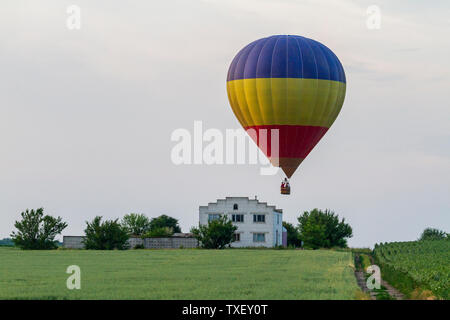 Ballon fliegt über das Feld und das Haus Stockfoto