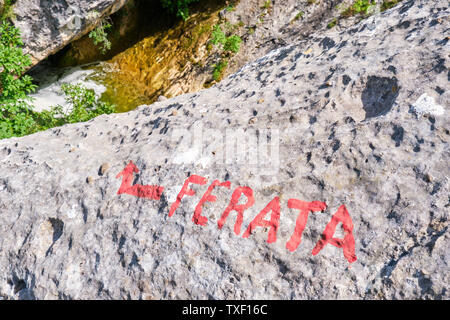 Das Wort ferata - (über) Klettersteig falsch geschrieben - in Rot auf einem Felsen in der cikola Canyon, Kroatien geschrieben. Stockfoto