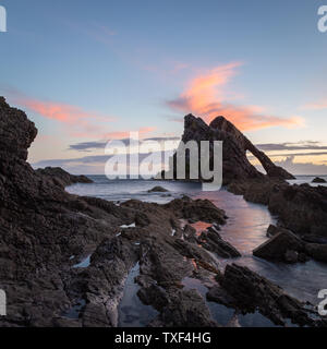 Sunrise Licht und Farben, die von den Ufern des Portknockie Stadt in der Nähe von Bogen Geige Felsformation. Schottische Highlands, Großbritannien, Europa. Stockfoto