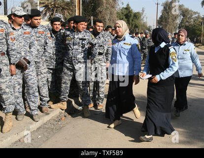 Irakische weibliche Polizisten vorbei an irakischen Armee Kommandos, wie Sie ankommen in der Irakischen Provinzwahlen in Bagdad, Irak, am Mittwoch, 28. Januar 2009 zu stimmen. Die Umfragen geöffnet Mittwoch für Mitglieder der irakischen Sicherheitskräfte, Häftlinge und die Vertriebenen. Allgemeine Abstimmung ist am Samstag, 31. Januar 2009. (UPI Foto/Ali Jasim) Stockfoto