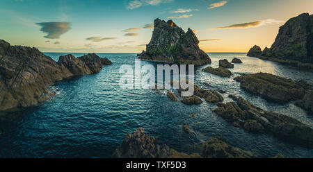 Sunrise Licht und Farben, die von den Ufern des Portknockie Stadt in der Nähe von Bogen Geige Felsformation. Schottische Highlands, Großbritannien, Europa. Stockfoto