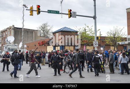 Anwohner und Polizei zu erfassen, indem eine ausgebrannte CVS-Store an der Ecke der West North Avenue und der Pennsylvania Avenue sammeln nach Marilyn Mosby, Baltimore City State Attorney, kuendigte Strafanzeige gegen die sechs Offiziere im Zusammenhang mit Freddie Grey's Verhaftung, in Baltimore gebracht wird, Maryland Mai 1, 2015. Mosby ordnete den Tod von Freddie Grau ein Totschlag und seine Festnahme illegal war. Grau, 25, die am 12. April verhaftet wurde, starb eine Woche später im Krankenhaus von Verletzungen des Rückenmarks erhielt er in Polizeigewahrsam. Foto von Kevin Dietsch/UPI Stockfoto