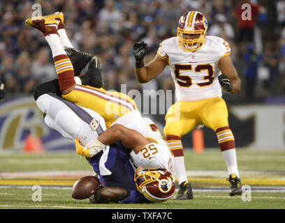 Baltimore Ravens wide receiver Kamar Aiken (L) ungeschickte Versuche den Fußball, wie er von Washington Redskins linebacker Keenan Robinson verordnungdrogeverkäufen ist (52) während der ersten Hälfte des preseason Football Spiel bei M&T Bank Stadium in Baltimore, 29. August 2015. Foto von David Tulis/UPI Stockfoto
