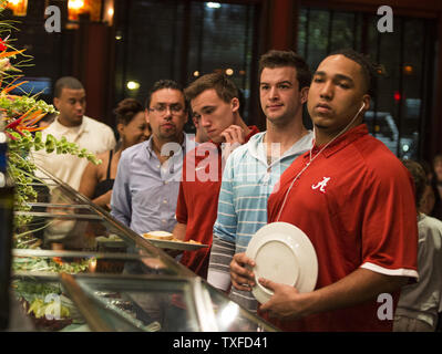 Universität von Alabama Football spieler Brandon Elfenbein (rechts) und Quarterback AJ McCarron (Zweiter von rechts), wie sie für mehr Salat innerhalb des Fogo de Chao Restaurant, wo das Team zum Abendessen in Miami Beach zum 4. Januar 2013 ging warten. Die Alabama Crimson Tide nehmen auf den Notre Dame Fighting Irish im BCS National Championship Januar 7, 2013. UPI/Mark Wallheiser Stockfoto