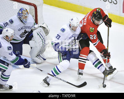 Chicago Blackhawks linken Flügel Troy Brouwer (R) und Vancouver Canucks Verteidiger Alexander Edler (23) aus Schweden für den Kobold als rechten Flügel Mikael Samuelsson (L) von Schweden und Torwart Cory Schneider in der zweiten Periode von Spiel 6 der NHL Western Conference verteidigen Viertelfinale in der vereinigten Mitte am 24. April in Chicago 2011. UPI/Brian Kersey Stockfoto