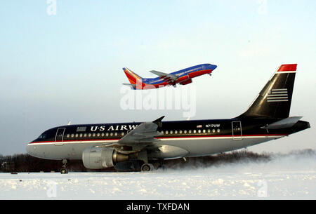 Eine Southwest Airlines Jet nimmt hinter einem US Airways Jet, wie es in Richtung Terminal Taxis, bei Bradley International Airport, mit einem schweren Sturm sich verjüngt, nachdem Dumping bis zu 18 "Schnee in der Region, Sonntag, 7. Dezember 2003, Windsor Locks, Anschl. Der Sturm gestrandet viele Passagiere in der gesamten Ostküste als verspäteter Flüge oder aufgrund der Wetterbedingungen abgesagt wurden. (UPI Foto/Steven E. Frischling) Stockfoto