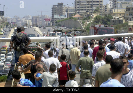 Menschen versammeln sich in einem kleinen Flugzeug, das auf einer vielbefahrenen Autobahn in Beirut am 3. Juli 2004 gelandet, nachdem technische Probleme. Nach Angaben von Zeugen, der Pilot hatte die Anwesenheit des Geistes seinen Kopf aus dem Fenster zu halten und zu kreischen an der Verkehr stoppt, Unfälle zu vermeiden (UPI Foto/Mohammed Tawil) Stockfoto