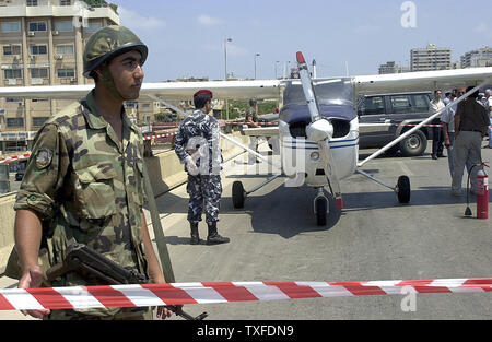 Menschen versammeln sich in einem kleinen Flugzeug, das auf einer vielbefahrenen Autobahn in Beirut am 3. Juli 2004 gelandet, nachdem technische Probleme. Nach Angaben von Zeugen, der Pilot hatte die Anwesenheit des Geistes seinen Kopf aus dem Fenster zu halten und zu kreischen an der Verkehr stoppt, Unfälle zu vermeiden (UPI Foto/Mohammed Tawil) Stockfoto