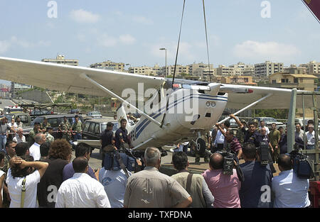 Menschen versammeln sich in einem kleinen Flugzeug, das auf einer vielbefahrenen Autobahn in Beirut am 3. Juli 2004 gelandet, nachdem technische Probleme. Nach Angaben von Zeugen, der Pilot hatte die Anwesenheit des Geistes seinen Kopf aus dem Fenster zu halten und zu kreischen an der Verkehr stoppt, Unfälle zu vermeiden (UPI Foto/Mohammed Tawil) Stockfoto