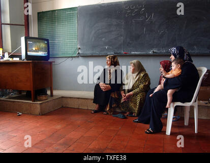 Flüchtlinge aus dem Südlibanon die Nachrichten im Fernsehen in einer Schule Unterricht in Beirut am 17. Juli 2006 Zehntausende meist libanesischen schiitischen Moslems sind auf der Flucht im Süden des Libanon und der Umzug in Schulen in anderen Teilen des Landes wie Israel seine Bombardements fort. Über hundert fünfzig Menschen im Libanon, meistens Zivilisten starben seit dem Konflikt am 12. Juli begann, nachdem die Hisbollah guerrillaÕs zwei israelische Soldaten entführt und getötet, sieben andere. (UPI Foto/Norbert Schiller) Stockfoto