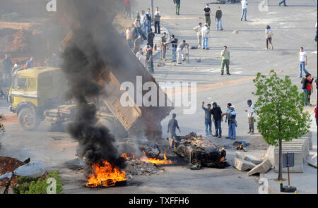 Ein Lastwagen kippt Schmutz auf dem Feuer, als die Demonstranten, verbündet mit der libanesischen Hisbollah - LED-politische Opposition, brennen Reifen, alte Autos und Straßen in der Hauptstadt Beirut am 7. Mai 2008. Eine allgemeine Arbeit Streik wurde für Gewerkschaften verlangt Einkommenserhoehungen genannt. Sporadische Gewehr - das Feuer war in der gesamten Hauptstadt gehört sowie Auseinandersetzungen zwischen rivalisierenden politischen Gruppen. Der Flughafen war auch geschlossen. (UPI Foto) Stockfoto