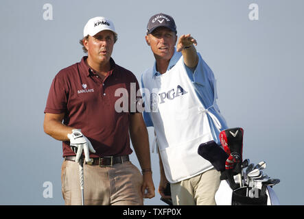 Phil Mickelson (L) spricht mit seinem caddie Jim Mackay auf der 3 T-Stück während der ersten Runde der 92 PGA Meisterschaft an den pfeifenden Straßen in Kohler, Wisconsin am 12. August 2010. UPI/Brian Kersey Stockfoto