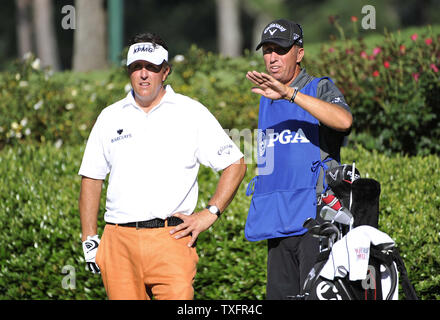 Phil Mickelson (L) spricht mit seinem caddie Jim Mackay auf dem 12., T-Stück in der ersten Runde des 93-PGA Meisterschaft am Atlanta Athletic Club am 11. August 2011 im Johns Creek, Georgia. UPI/Brian Kersey Stockfoto