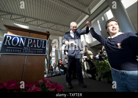 Andrew Struss (R), ein Anhänger der republikanischen Präsidentschaftskandidaten Ron Paul, hält Paul's Hand, nachdem Paul Verfechter bei einer Wahlkampfveranstaltung am 2. Januar in Cedar Rapids, Iowa 2012 gerichtet. UPI/Brian Kersey Stockfoto