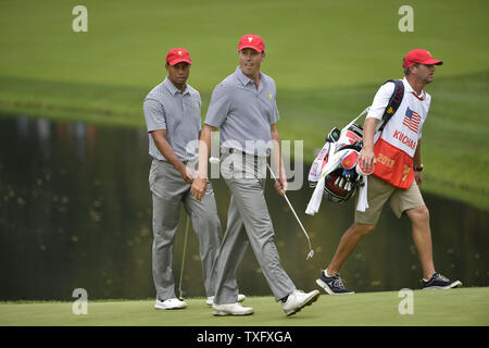 United States Team Mitglieder Tiger Woods (L) und Matt Kuchar zu Fuß bis zum fünften Fairway in der zweiten Runde zu viert Konkurrenz gegen die internationale Mannschaft an den Präsidenten Cup 2013 in Muirfield Village Golf Club in Dublin, Ohio am 4. Oktober 2013. UPI/Brian Kersey Stockfoto