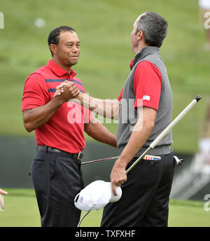 United States Team Mitglieder Tiger Woods und Matt Kuchar feiern ihren 4 und 2 Gewinnen über Internationales Team Mitglieder Louis Oosthuizen und Charl Schwartzel, sowohl von Südafrika, auf dem 16 Grün während der zweiten Runde zu viert Konkurrenz an den Präsidenten Cup 2013 in Muirfield Village Golf Club in Dublin, Ohio am 5. Oktober 2013. UPI/Brian Kersey Stockfoto