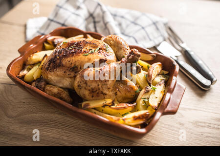 Gebratene ganze Hähnchen mit Kartoffeln, in Auflaufform. Leckeres Essen ein Stockfoto